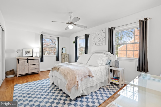 bedroom with ceiling fan, baseboards, and wood finished floors