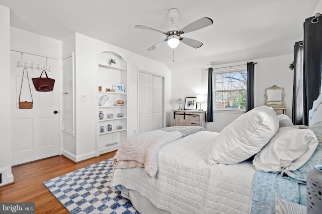 bedroom featuring light wood-style flooring, ceiling fan, and a closet