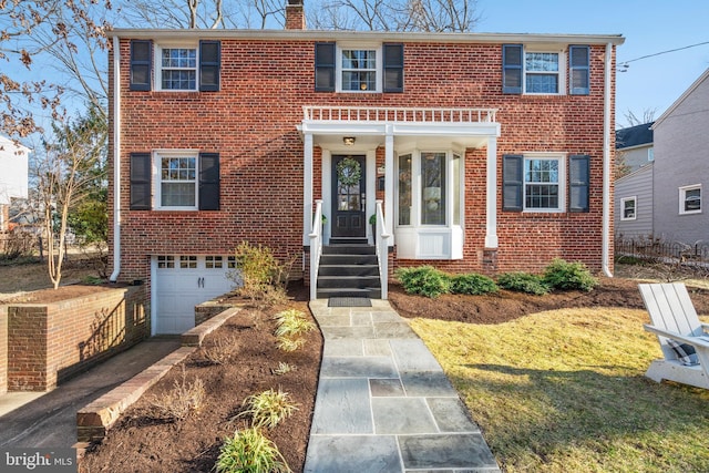 view of front of property with driveway, brick siding, and a chimney