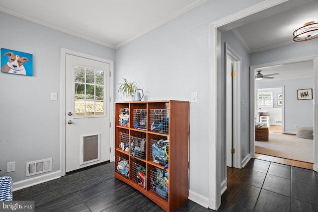 entryway with baseboards, crown molding, visible vents, and a wealth of natural light