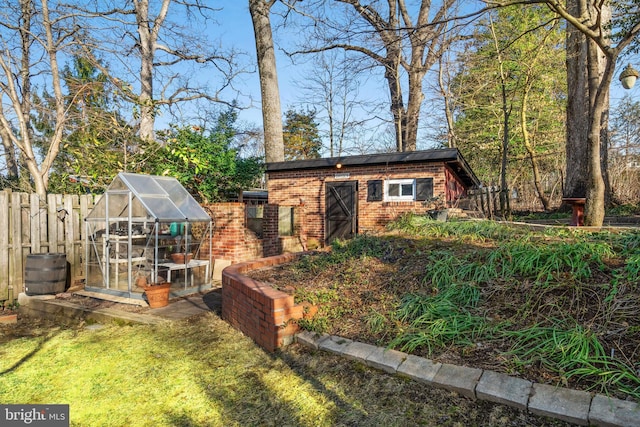 view of greenhouse featuring fence