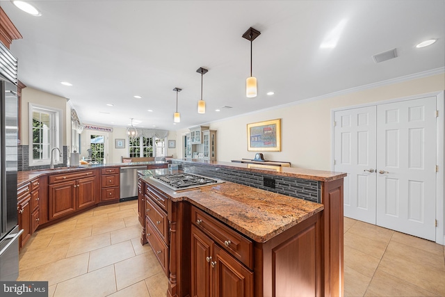 kitchen with light tile patterned flooring, appliances with stainless steel finishes, a center island, and a sink