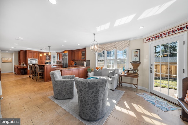 living area with a notable chandelier, recessed lighting, crown molding, and baseboards