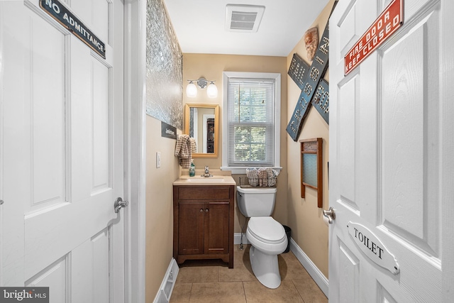 bathroom featuring tile patterned flooring, visible vents, baseboards, toilet, and vanity