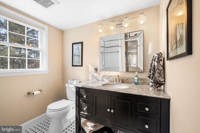 half bath featuring vanity, visible vents, baseboards, tile patterned flooring, and toilet