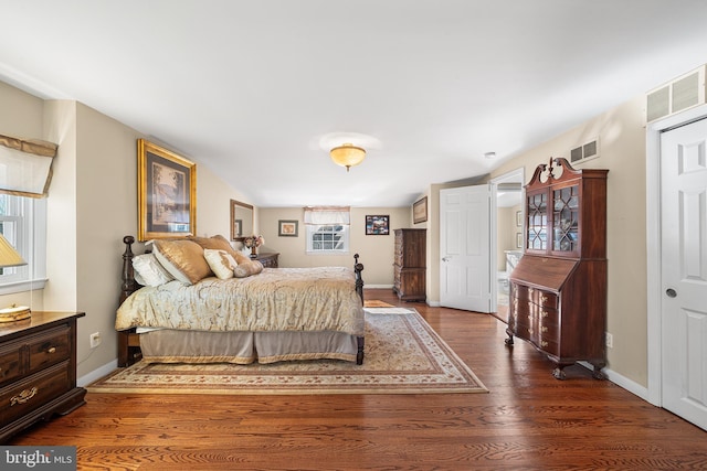 bedroom featuring visible vents, baseboards, and dark wood-type flooring