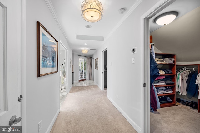 hall with crown molding, light colored carpet, and baseboards