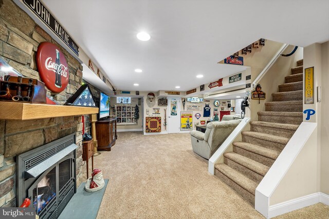 carpeted living room featuring a stone fireplace, stairway, recessed lighting, and baseboards