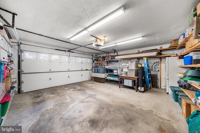 garage with a garage door opener and freestanding refrigerator