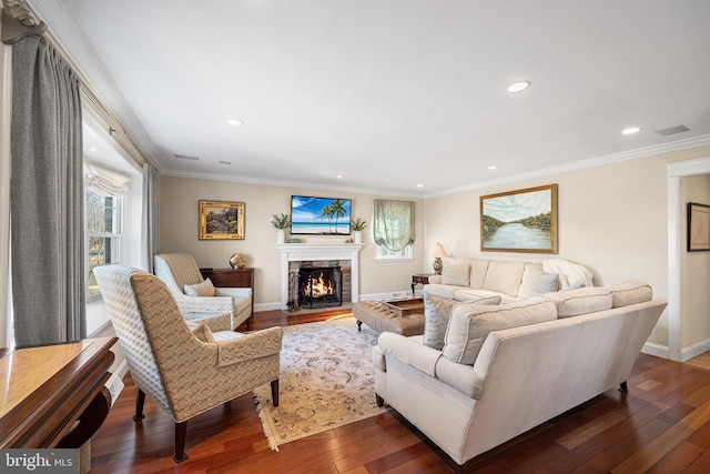 living area with crown molding, baseboards, dark wood finished floors, recessed lighting, and a fireplace