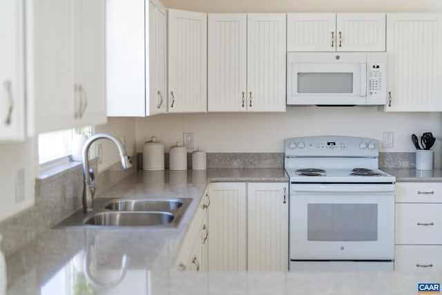 kitchen featuring light countertops, white appliances, a sink, and white cabinets