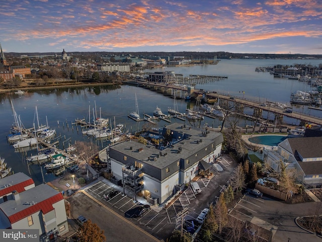 aerial view at dusk featuring a water view