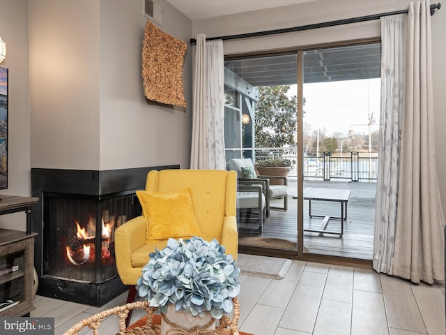 sitting room with a multi sided fireplace and visible vents