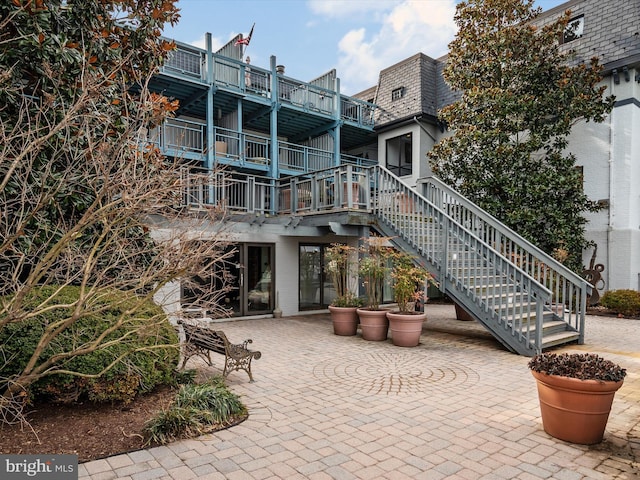 back of property with a patio area and stairs