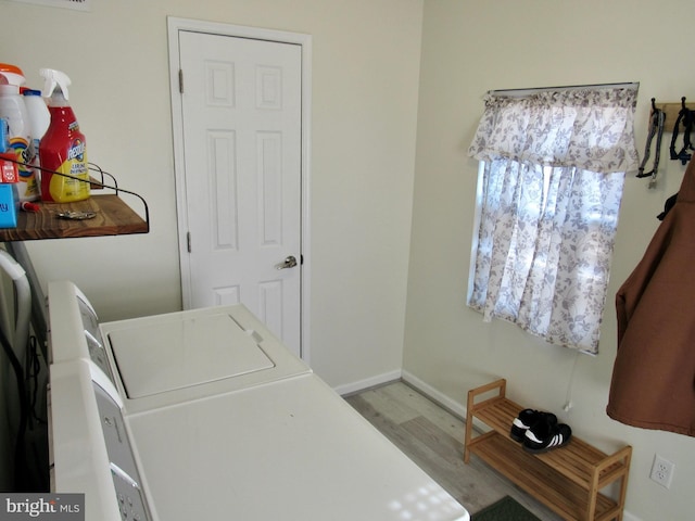 laundry area featuring baseboards, laundry area, washing machine and dryer, and light wood-style floors