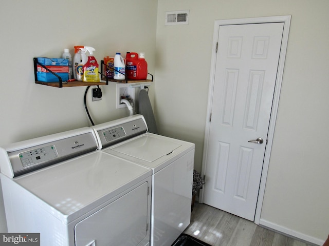 laundry room featuring laundry area, separate washer and dryer, light wood-type flooring, and visible vents