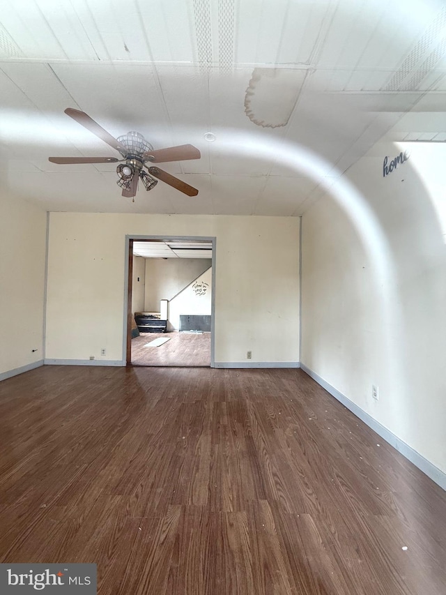 unfurnished room featuring wood finished floors, a ceiling fan, and baseboards