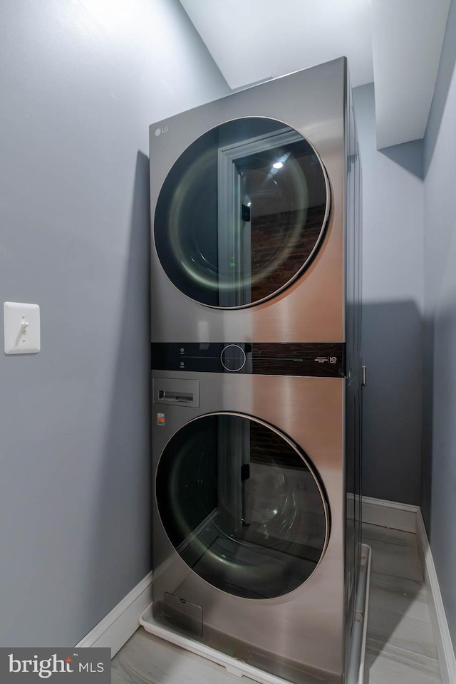 laundry room featuring stacked washer and dryer, baseboards, and laundry area