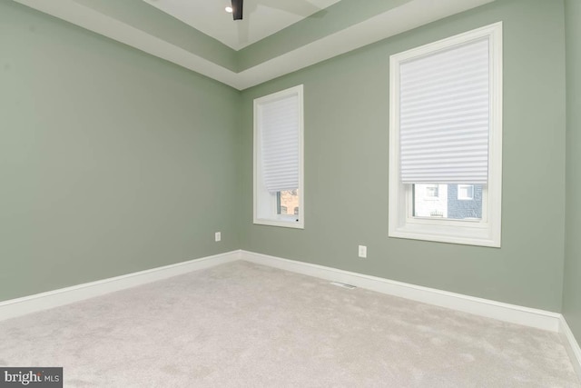 unfurnished room with ceiling fan, plenty of natural light, carpet flooring, and baseboards