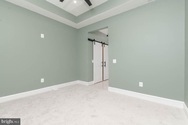 spare room featuring a barn door, baseboards, ceiling fan, carpet flooring, and recessed lighting