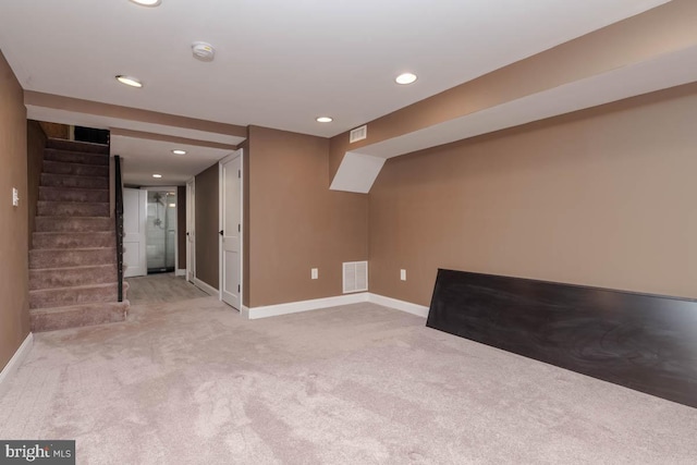 finished basement featuring carpet, stairs, visible vents, and baseboards