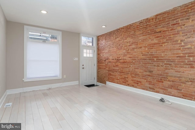 foyer entrance featuring brick wall, recessed lighting, wood finished floors, and baseboards