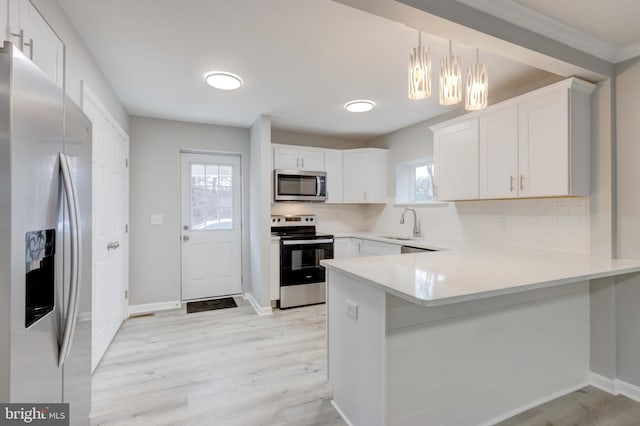 kitchen featuring stainless steel appliances, light countertops, and white cabinets