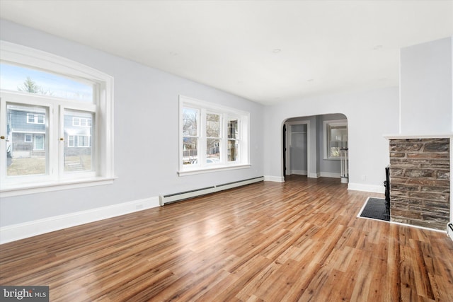 117 Morningside Dr, Trenton, NJ 08618 - unfurnished living room with light wood finished floors, a baseboard radiator, arched walkways, and baseboards