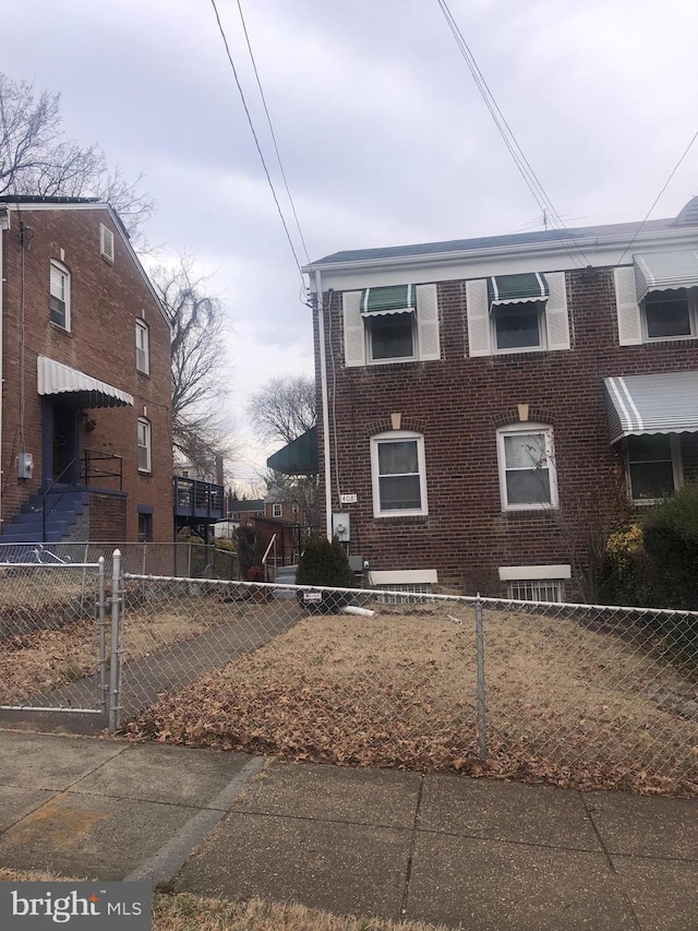 view of front of home with a fenced front yard and brick siding