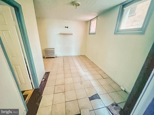 hallway featuring radiator and tile patterned flooring