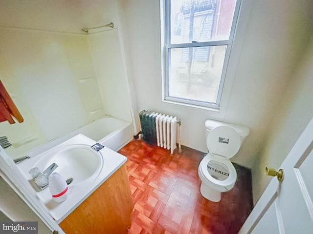 bathroom featuring toilet, vanity, and radiator heating unit