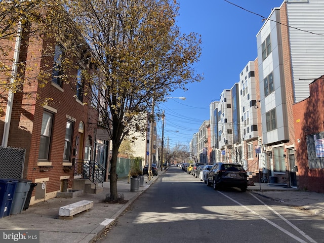 view of road featuring street lights, curbs, and sidewalks