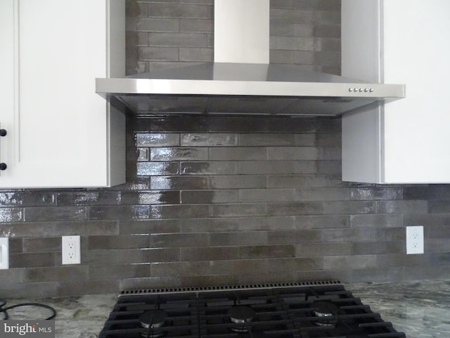 details with wall chimney range hood, tasteful backsplash, and light countertops