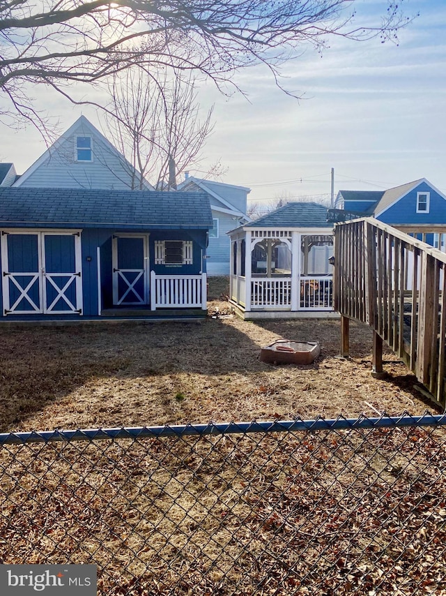 exterior space featuring a shingled roof and a gazebo