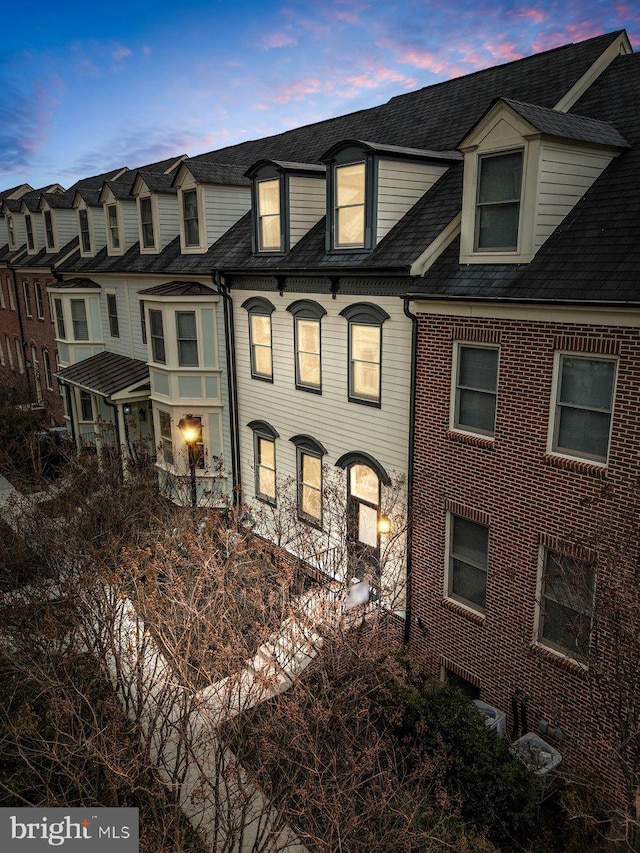 townhome / multi-family property featuring brick siding and a shingled roof