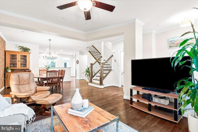 living room featuring baseboards, crown molding, stairway, and dark wood-style flooring