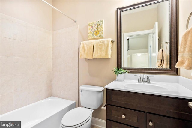 bathroom featuring toilet, baseboards, tub / shower combination, and vanity