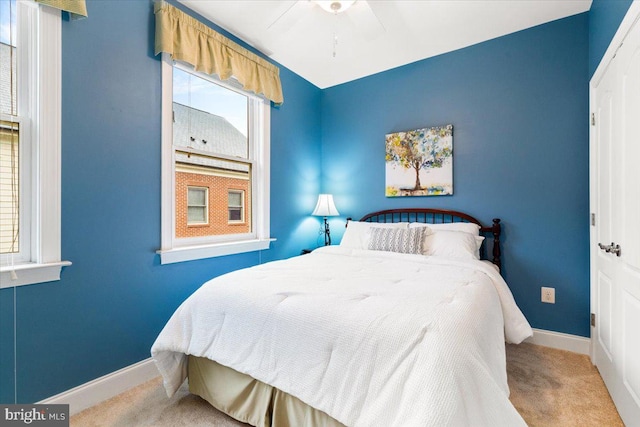 bedroom with baseboards, ceiling fan, and light colored carpet