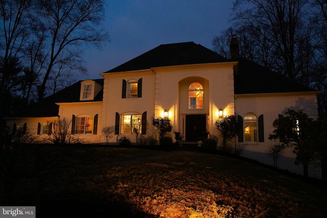 mediterranean / spanish-style house with a chimney and stucco siding