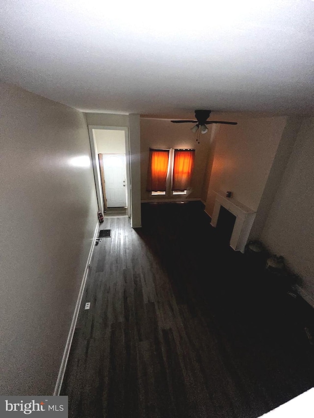 corridor featuring dark wood-style floors and baseboards