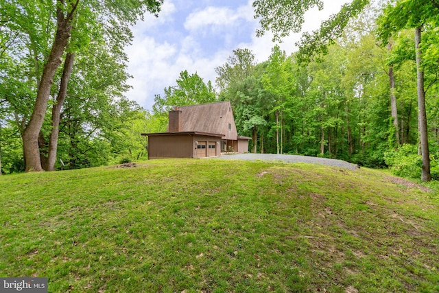 15431 Machodoc Dr, King George, VA 22485 - view of grassy yard featuring a garage and a view of trees