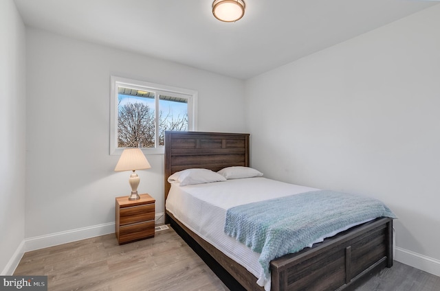 bedroom featuring baseboards and wood finished floors