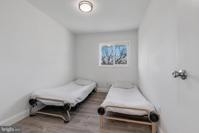 bedroom featuring baseboards and wood finished floors