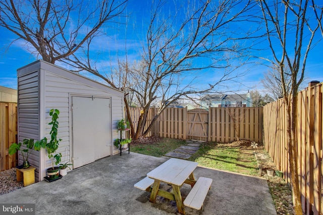 view of yard featuring a storage shed, a patio, an outdoor structure, and a fenced backyard