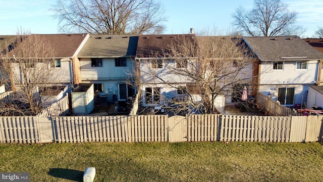 back of property with a lawn and fence private yard