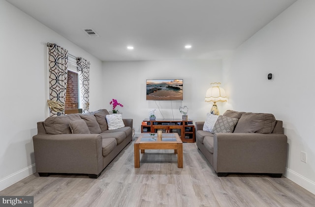 living room featuring recessed lighting, baseboards, and light wood finished floors