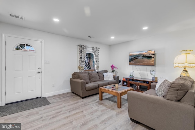 living room with light wood-style floors, visible vents, and recessed lighting