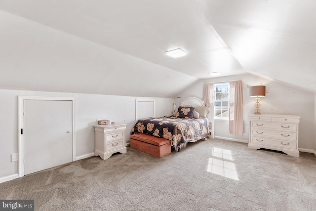 carpeted bedroom with vaulted ceiling and baseboards