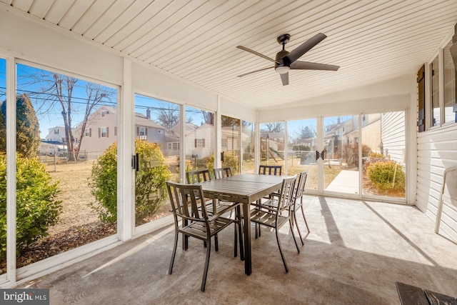 sunroom / solarium with ceiling fan and a residential view