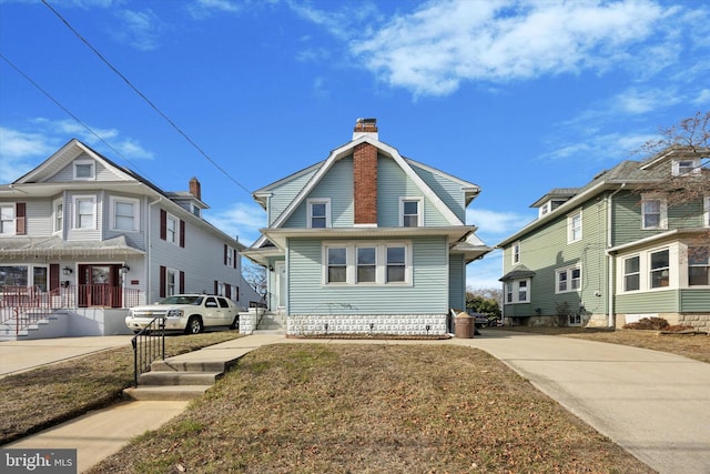 view of front of home featuring a chimney and a gambrel roof